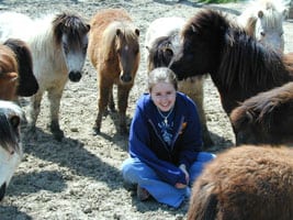 teenager on ground miniature horses circling her minis texas
